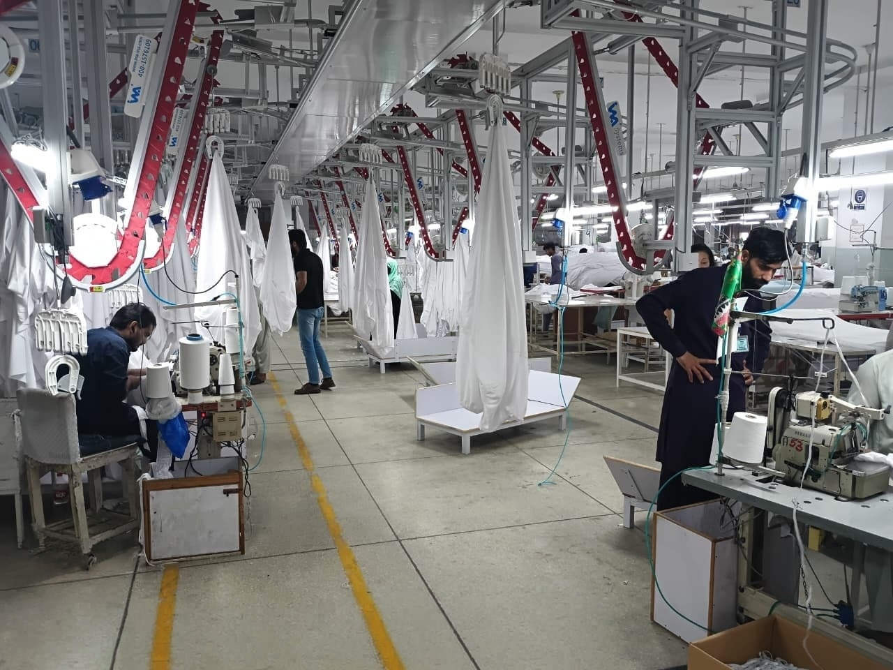 Modern stitching floor with industrial sewing machines and skilled operators
